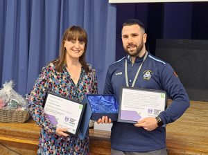 Linda James and Mr Evans holding certificates and a trophy
